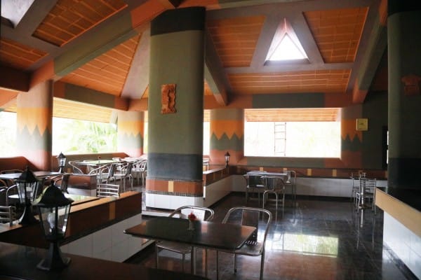 Dining hall with steel tables and chairs below clerestory windows