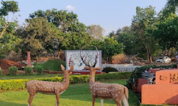 Deer sculptures on the lawn beside a tiled mural