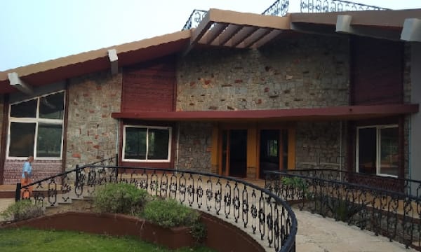 Stone-clad main treatment building behind a curved wrought-iron railing