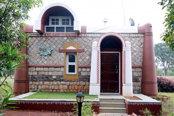 Front elevation of a stone guest cottage with arched doorway